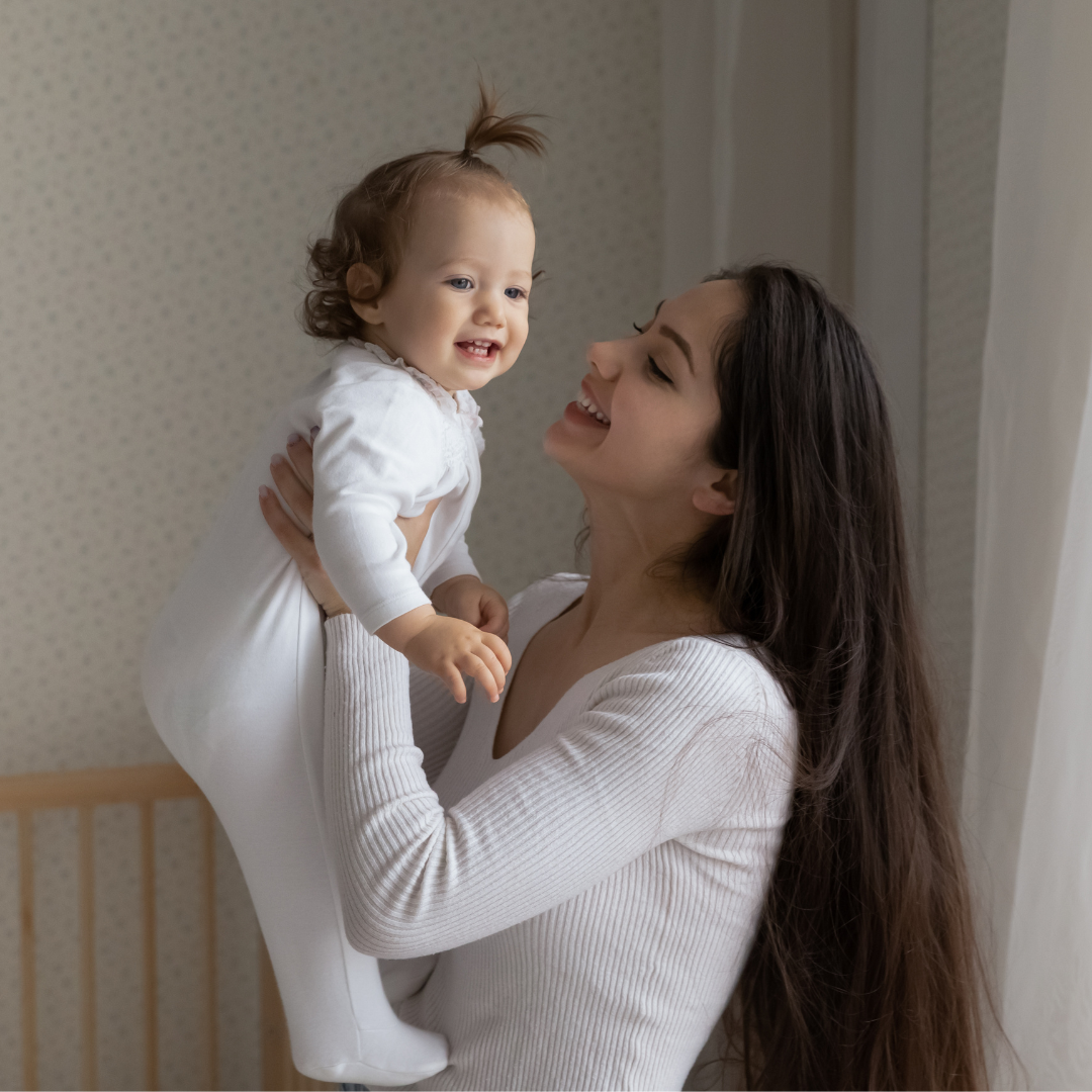 nanny holding a baby smiling