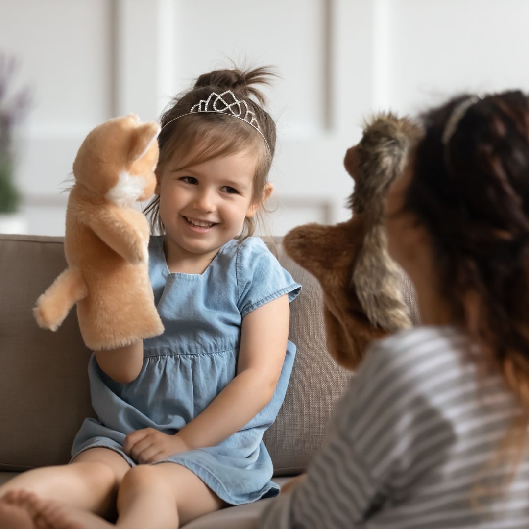 Little princess playing with the nanny with puppets